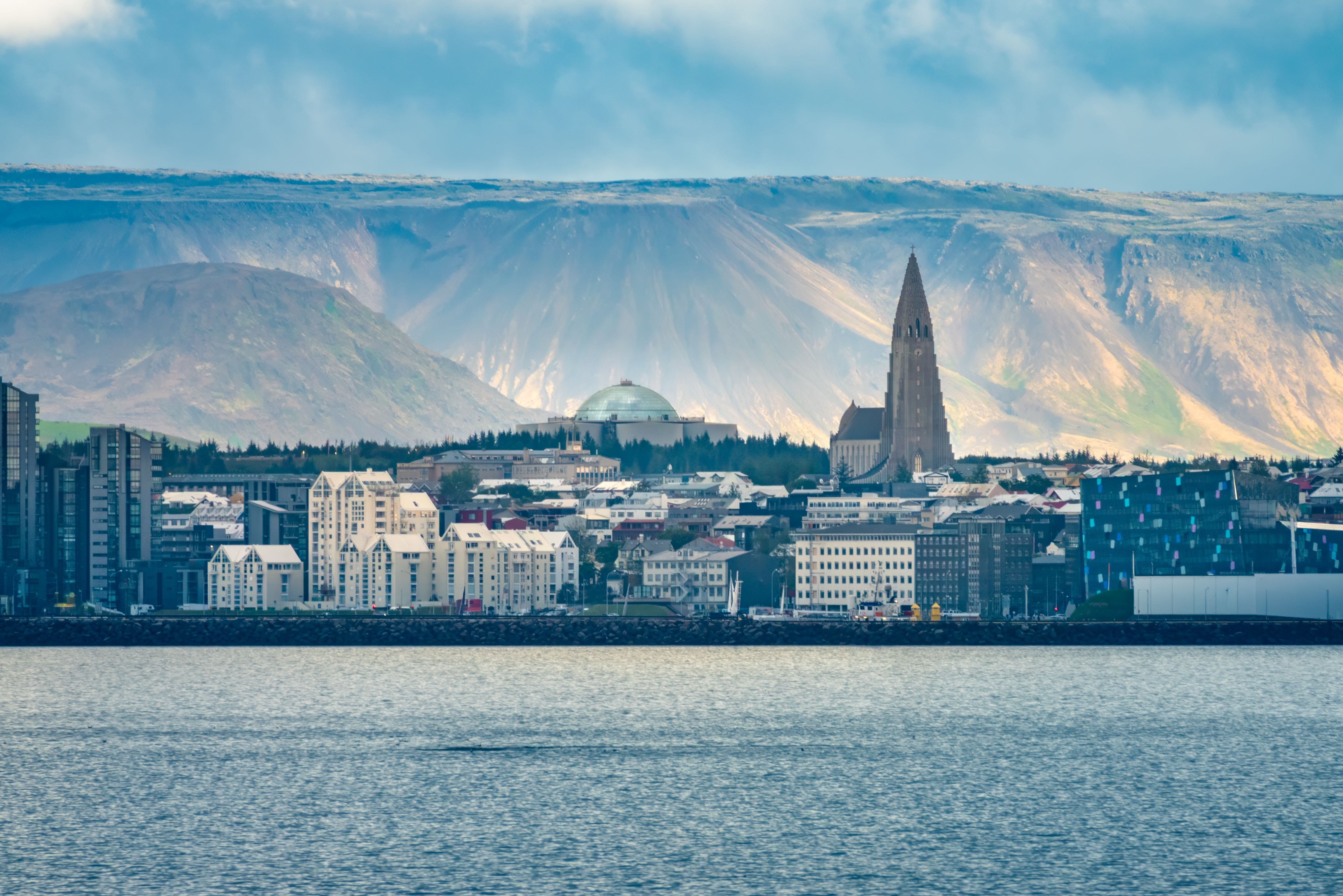 Reykjavik Cruise Port skyline with Hallgrímskirkja church and Harpa Concert Hall, framed by Iceland’s dramatic mountains and waterfront on a scenic cruise arrival.