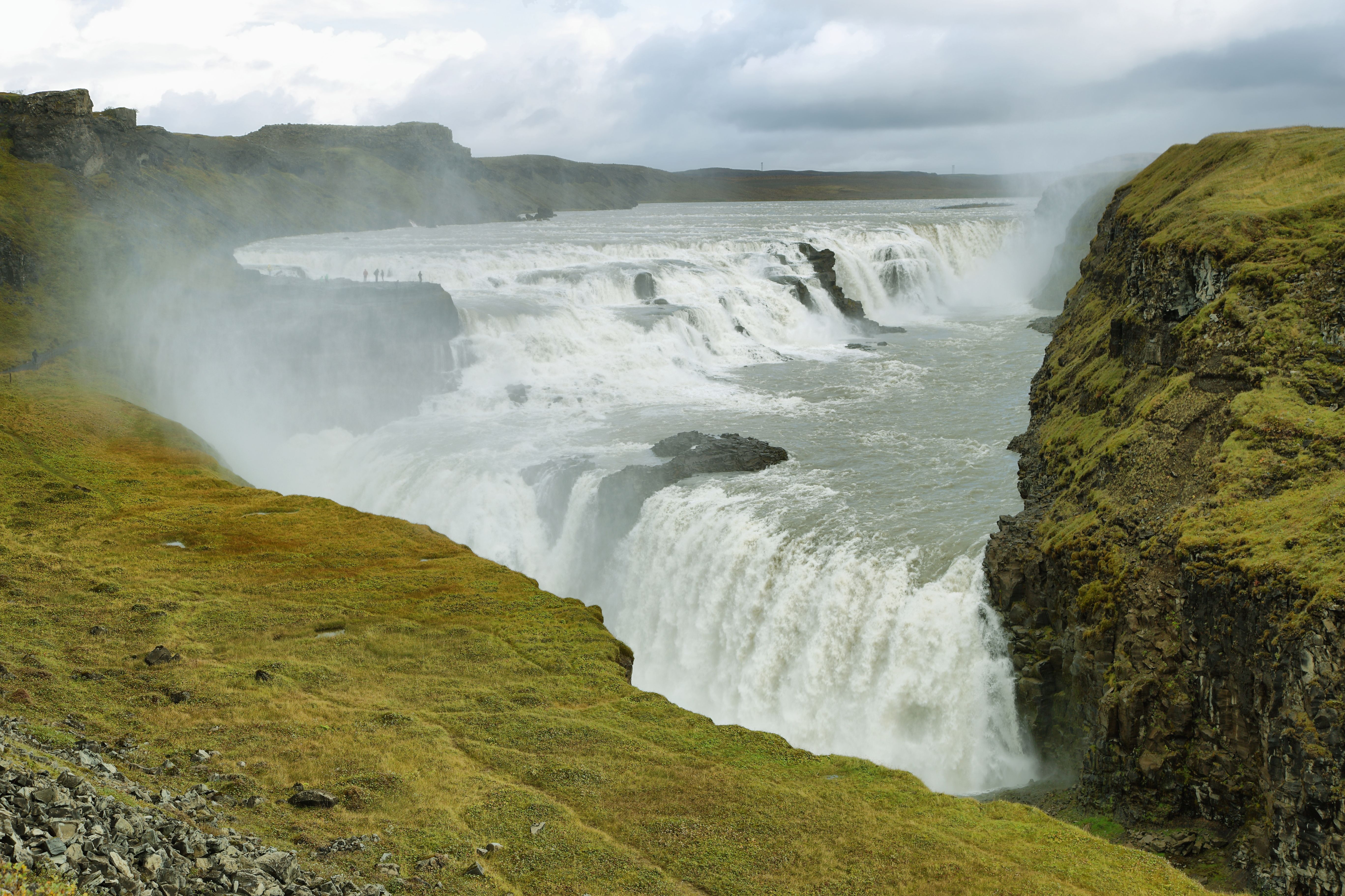 Gullfoss waterfall in Iceland’s Golden Circle, cascading through a dramatic canyon with misty cliffs and rugged landscapes on a popular shore excursion.