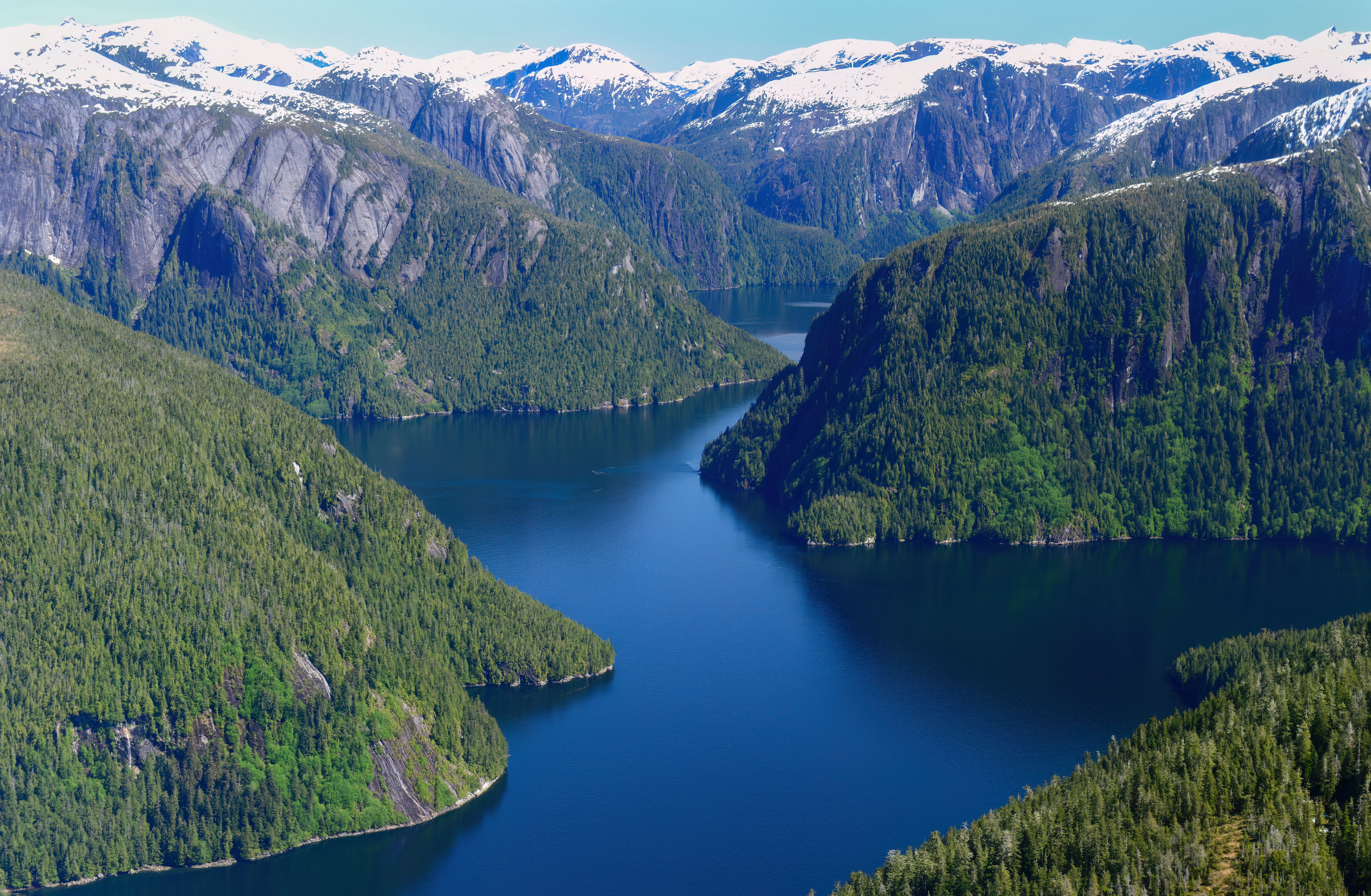 Misty Fjords flightseeing excursion over Alaska’s Misty Fjords National Monument, featuring towering granite cliffs, snow-capped peaks, forested valleys and deep blue fjords.