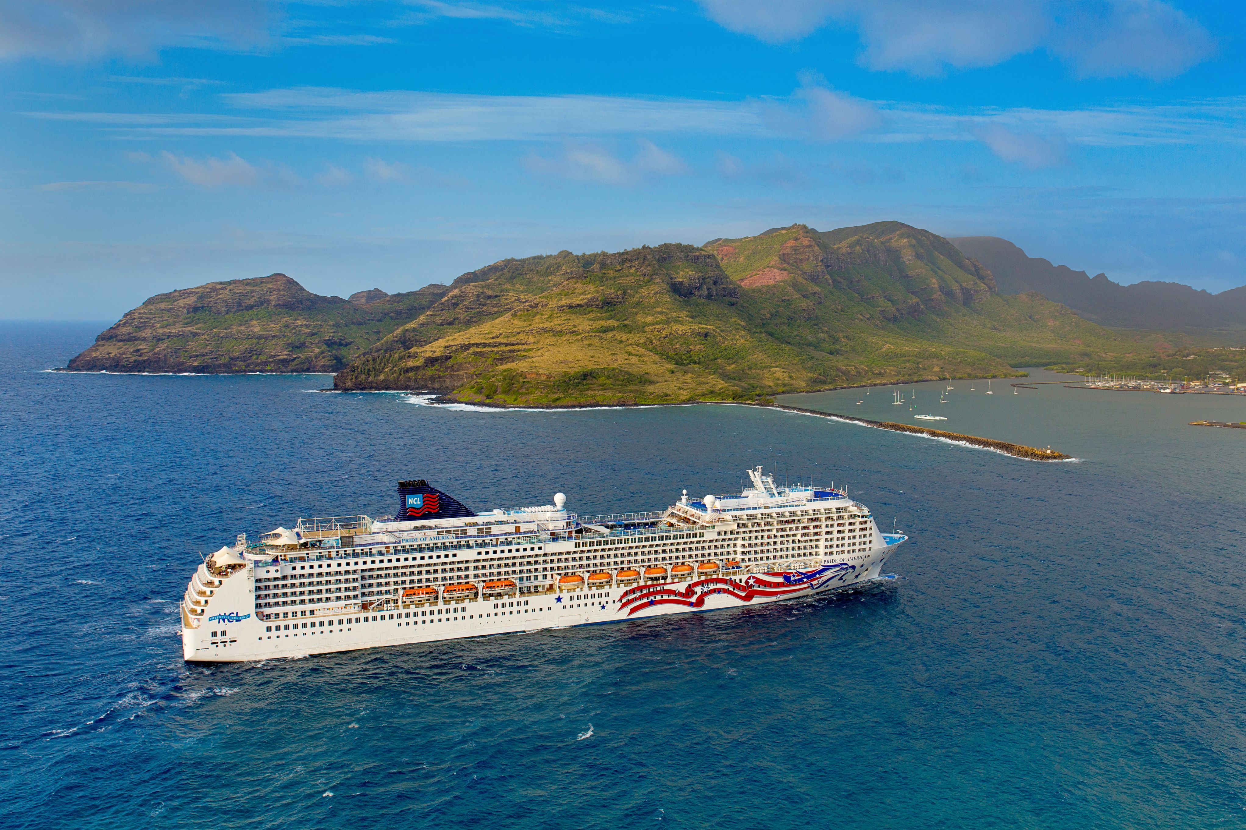 Pride of America cruise ship sailing near Nawiliwili, Kauai, Hawaii, with lush green mountains and the island’s scenic coastline in the background.