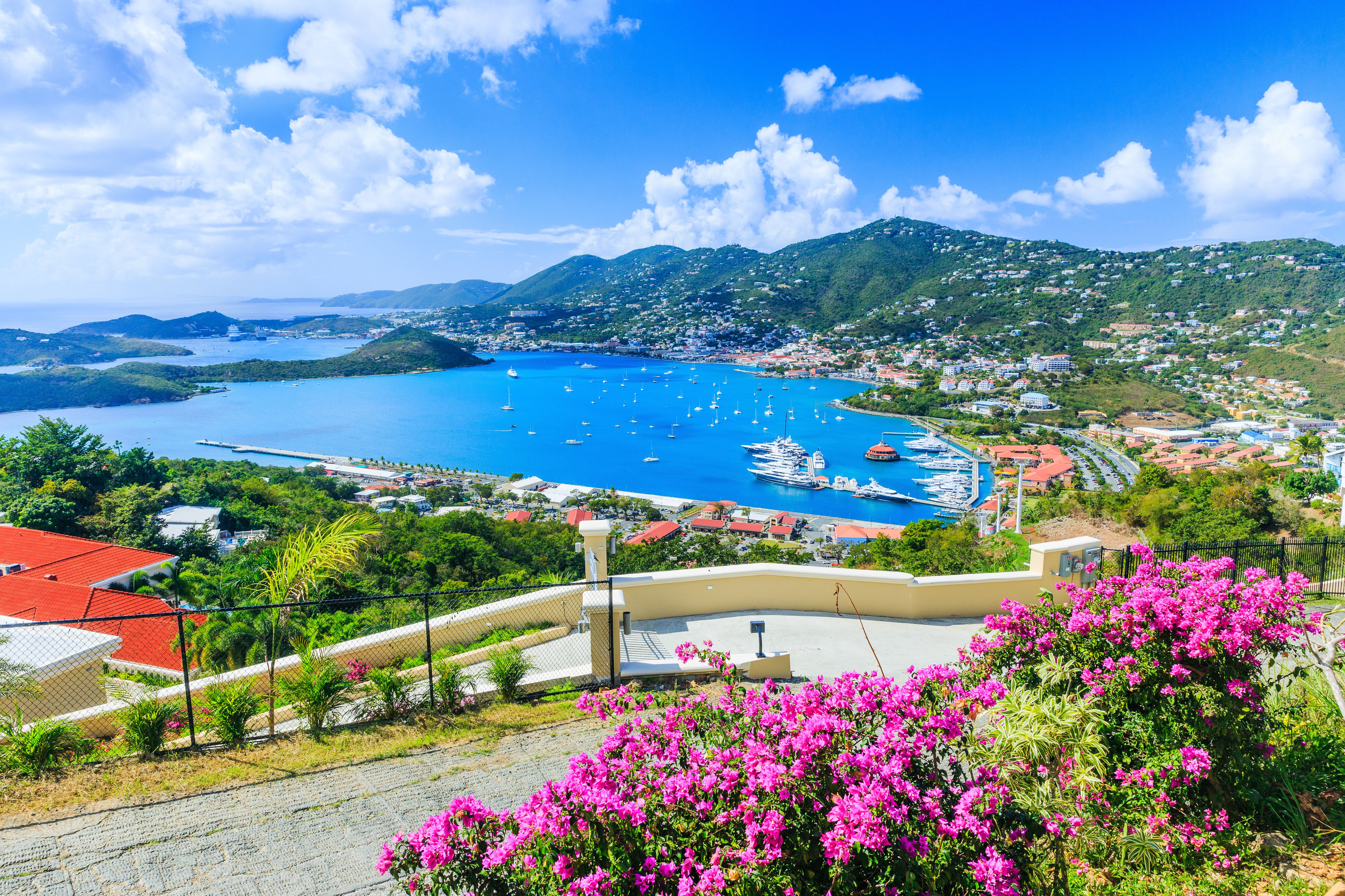 Scenic view of Charlotte Amalie harbor in St. Thomas, U.S. Virgin Islands, with yachts, turquoise Caribbean waters and lush green hills.