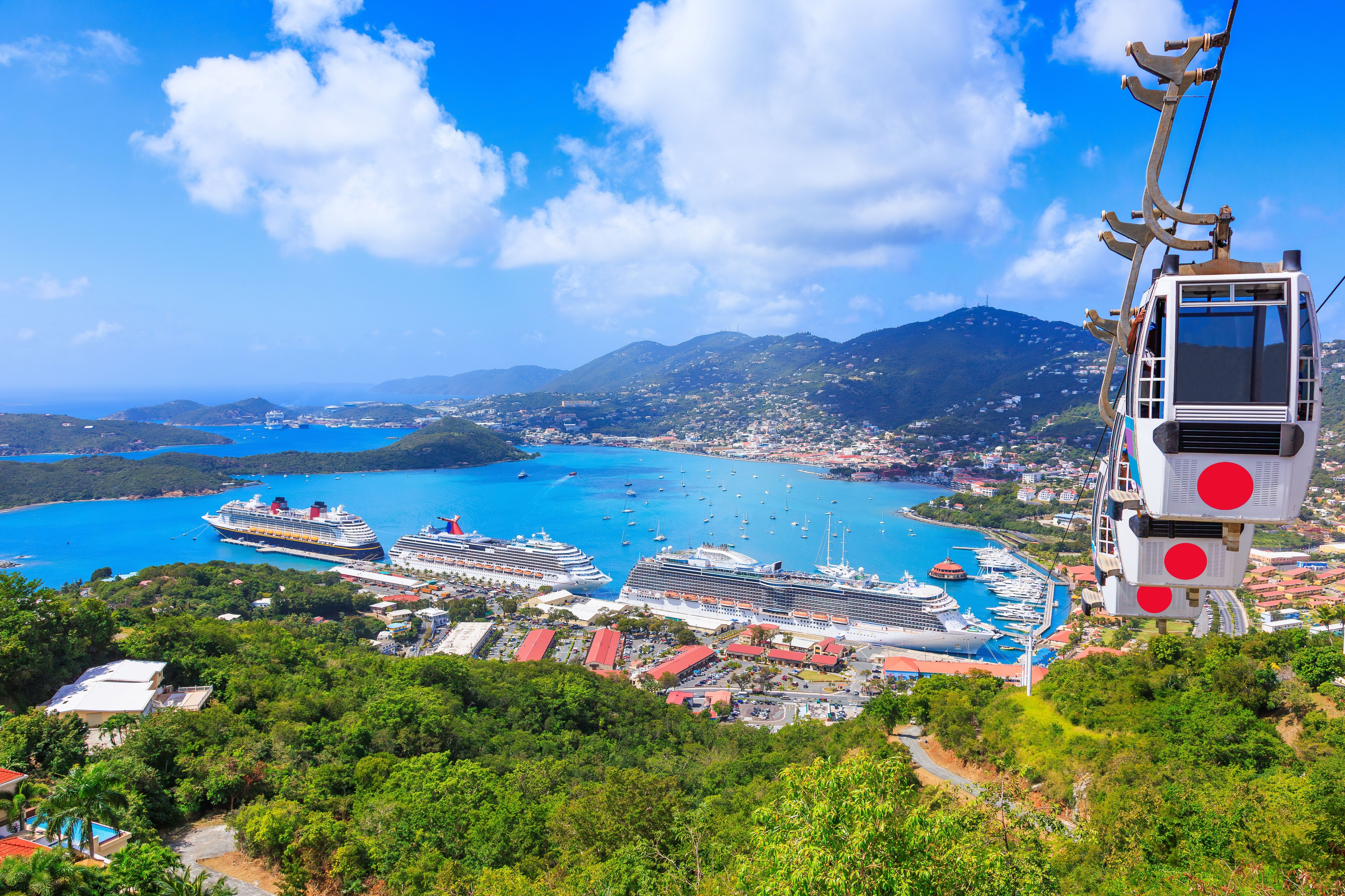 St. Thomas cruise port in the U.S. Virgin Islands, with cruise ships docked in turquoise Caribbean waters and a scenic aerial tramway.