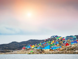 Reihe farbenfroher Holzh&auml;user am Wasser im ruhigen Dorf in der Antarktis
