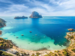 Mediterrane Badebucht mit Booten und ruhigem Wasser aus der Vogelperspektive