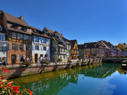 Reihe bunter Fachwerkh&auml;user mit steilen D&auml;chern unter klarem, blauem Himmel