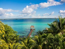 Costa Maya, Mexiko &ndash; t&uuml;rkisfarbene Lagune mit Palmen und Holzsteg