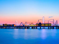Galveston, USA &ndash; Vergn&uuml;gungspier mit Riesenrad leuchtet im Abendlicht &uuml;ber dem Meer