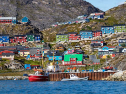 Qaqortoq, Gr&ouml;nland &ndash; Bunte Holzh&auml;user am Hang &uuml;ber dem Hafen mit Fischerbooten
