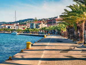 Argostoli, Griechenland &ndash; mediterrane Hafenpromenade mit Blick auf Berge und Segelboot