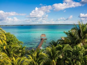Costa Maya, Mexiko &ndash; t&uuml;rkisfarbene Lagune mit Palmen und Holzsteg