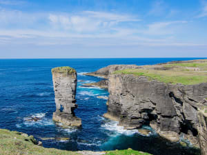 Kirkwall, Schottland &ndash; Wellen schlagen an raue Felsen mit nat&uuml;rlichem Felsturm
