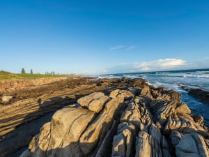 Port Elizabeth, S&uuml;dafrika &ndash; Geschichtete Felsformationen treffen auf wilde Brandung