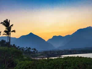 Kahului, USA &ndash; Palmen und Berge im Gegenlicht eines goldenen Sonnenuntergangs