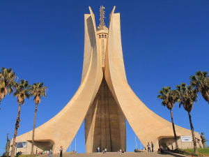 Algier, Algerien &ndash; Monument der M&auml;rtyrer als Wahrzeichen mit Palmen im Vordergrund