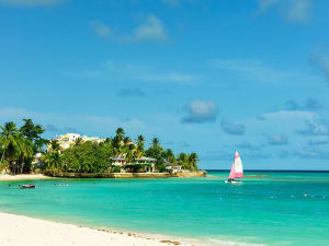 Bridgetown, Barbados - Wei&szlig;er Sandstrand mit Segelboot im t&uuml;rkisblauen Meer