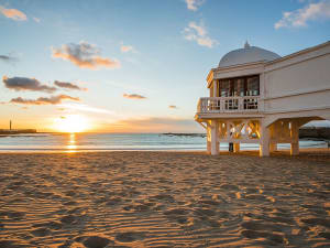 C&aacute;diz, Spanien &ndash; Sonnenuntergang am Strand La Caleta mit Pavillon