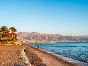 Aqaba, Jordanien &ndash; Sandstrand mit Palmen und Blick auf das Rote Meer
