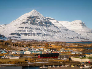 Dj&uacute;pivogur, Island &ndash; K&uuml;stenort mit Hafen und eindrucksvoller Bergkulisse im Sonnenlicht
