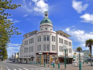 Napier, Neuseeland &ndash; Architektur im Art-d&eacute;co-Stil mit Uhrturm und Palmen unter blauem Himmel