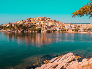 Kavala, Griechenland &ndash; Goldene H&auml;userfassaden spiegeln sich im ruhigen Hafenwasser