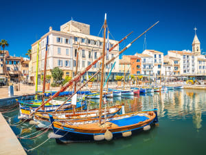 Sanary-sur-Mer, Frankreich &ndash; traditionelle Boote im lebhaften Hafen vor pastellfarbener Altstadt