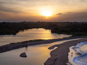 Hambantota (Sri Lanka) - Sonnenuntergang &uuml;ber Lagune und Sandstrand mit ruhigem Wasser und dichter Vegetation
