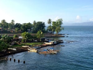 Alotau, Pap&uacute;a Nueva Guinea &ndash; Bah&iacute;a tropical con embarcaciones y palmeras junto al mar
