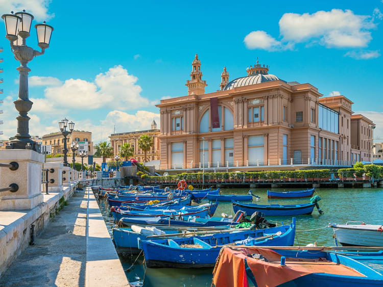 Bari, Italien &ndash; bunte Fischerboote d&uuml;mpeln im Hafen vor dem historisch eleganten Teatro Margherita