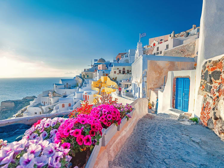 Santorini, Griechenland &ndash; blaue T&uuml;ren und Bl&uuml;tenmeer f&uuml;hren zur Kreuzfahrtidylle