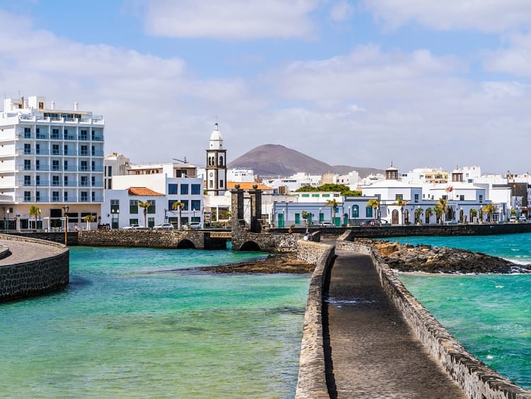 Arrecife, Kanaren &ndash; Ein Steg &uuml;ber dem Wasser f&uuml;hrt zur wei&szlig;en Stadt