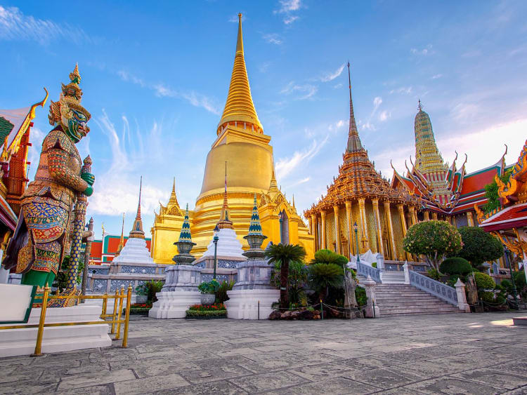 Bangkok, Thailand &ndash; Goldene Chedi und W&auml;chterfigur am Tempel Wat Phra Kaeo erwarten Sie
