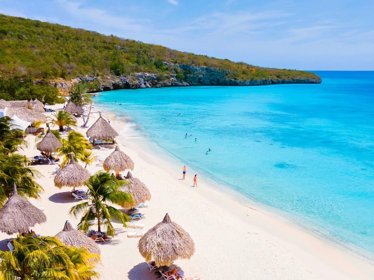 Willemstad, Cura&ccedil;ao &ndash; Wei&szlig;er Sandstrand unter Palmen vor leuchtender Bucht