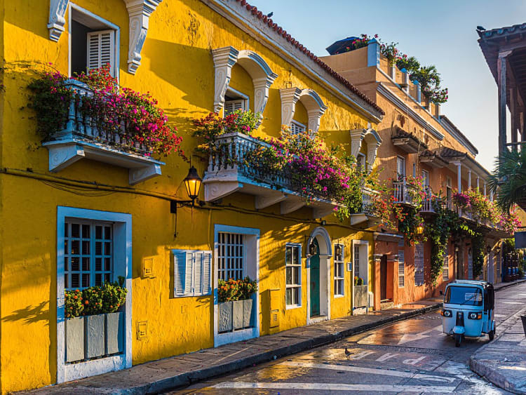 Cartagena, Kolumbien &ndash; gelbe Altstadth&auml;user mit Blumenbalkonen und Tuk-Tuk