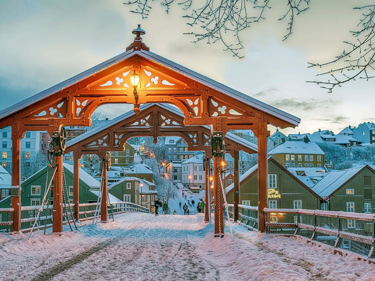 Trondheim, Norwegen &ndash; verschneite Altstadt mit roter Holzbr&uuml;cke im Abendlicht