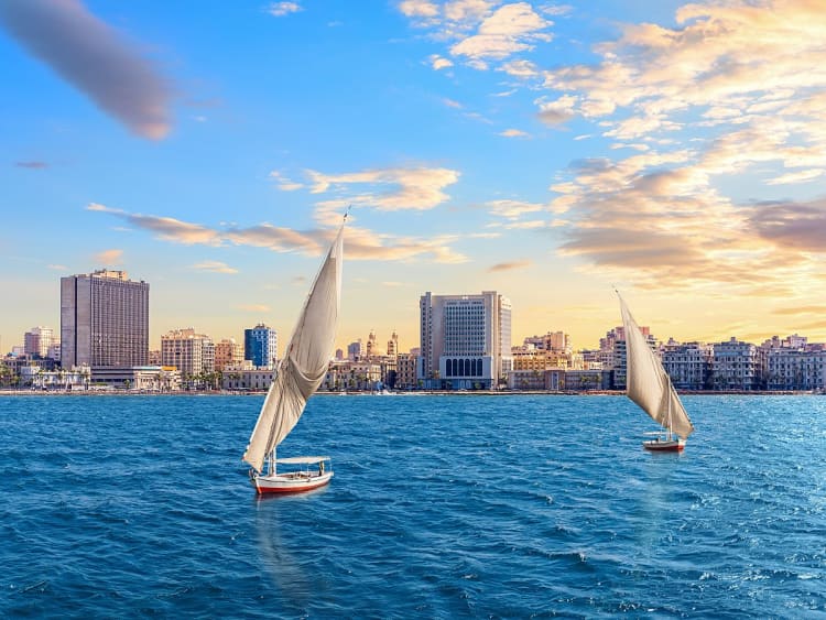 Alexandria, &Auml;gypten &ndash; zwei Segelboote vor moderner K&uuml;stenlinie im Abendlicht