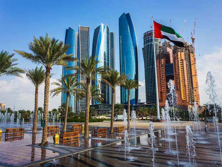 Abu Dhabi, VAE &ndash; moderne Etihad Towers ragen hinter Palmen und Wasserspielen