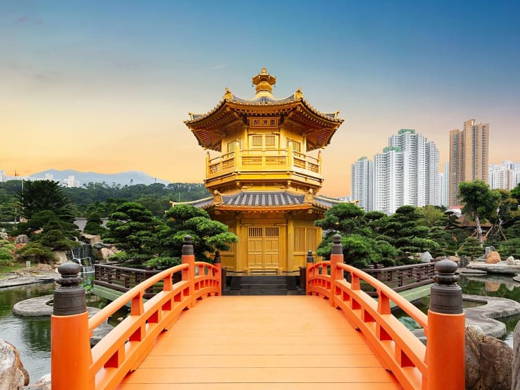 Hongkong, China &ndash; Goldener Pavillon im Zen-Garten vor Skyline bei sanftem Abendlicht