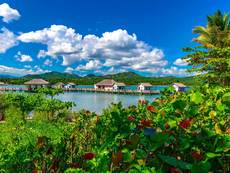 Amber Cove, Dominikanische Republik - Reihenhausartige Bungalows schweben &uuml;ber t&uuml;rkisblauer Lagune und Palmen