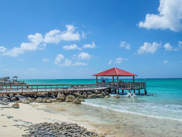 Princess Cays, Bahamas &ndash; Roter Pavillon am Steg &uuml;ber klaren Wellen und hellem Sand