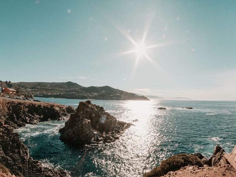 Ensenada, Mexiko - Sonnenstrahlen spiegeln sich auf dem Meer vor rauer K&uuml;stenlinie