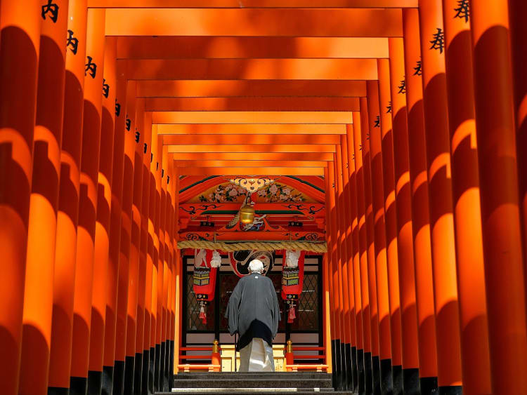 Kobe, Japan &ndash; Tiefblick durch Torii auf Priester im Eingangsbereich des Schreins