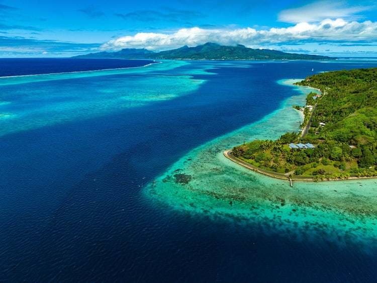 Raiatea, Franz.-Polynesien - Gr&uuml;ne K&uuml;ste mit Stra&szlig;e entlang glasklarer Lagune nach Moorea