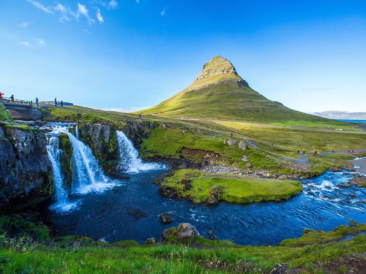 Grundarfj&ouml;r&eth;ur, Island &ndash; Kirkjufell spiegelt sich im Wasserfall vor klarblauem Himmel