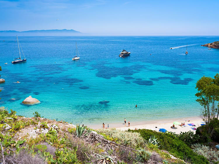Porto Santo Stefano, Italien &ndash; Feiner Sandstrand mit Blick auf Segelboote im klaren Meer