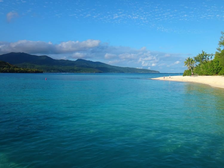 Mystery Island, Vanuatu - Sanfte Wellen treffen auf wei&szlig;en Sand vor gr&uuml;nen H&uuml;geln