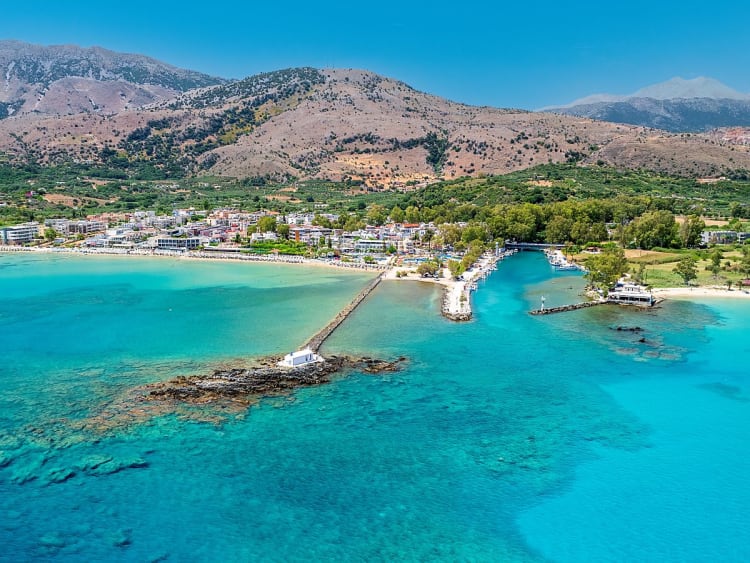 Agios Nikolaos, Griechenland &ndash; K&uuml;stenort mit Pier und Kapelle im t&uuml;rkisblauen Meer