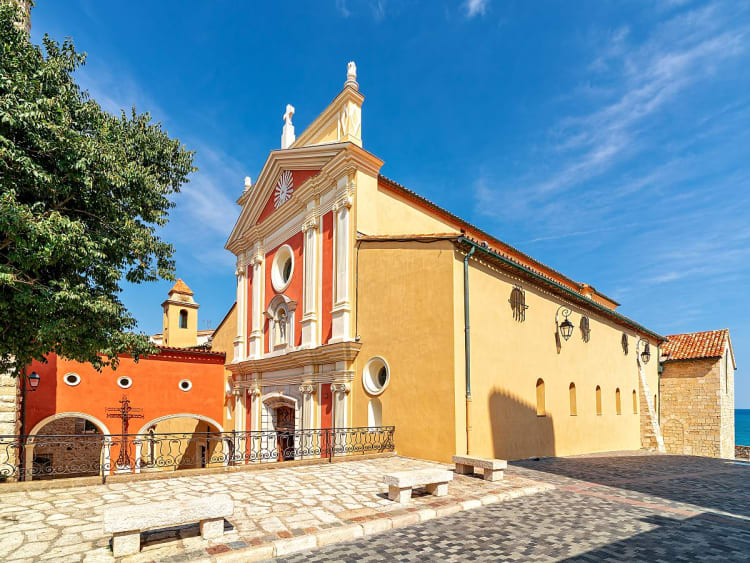 Antibes, Frankreich &ndash; Barockkirche im warmen Farbton mit Blick aufs Meer