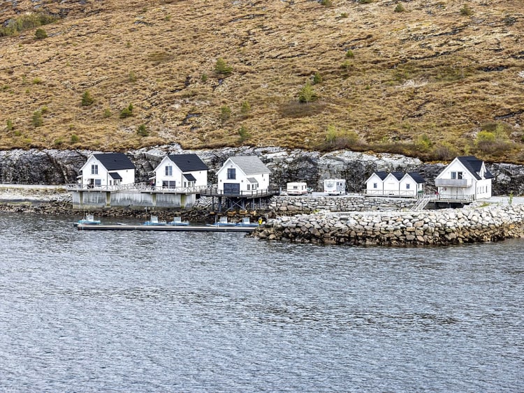 Bessaker, Norwegen - Wei&szlig;e Holzh&auml;user auf Stelzen am Fjordufer