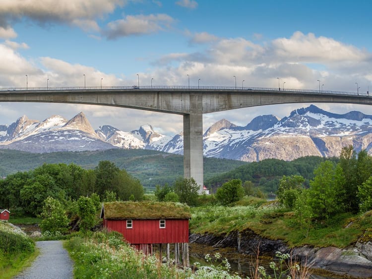Bod&oslash;, Norwegen &ndash; Br&uuml;cke vor schneebedeckten Bergen und rotem Haus