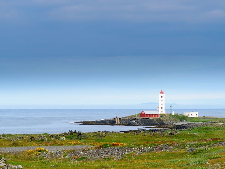 Berlev&aring;g, Norwegen - K&uuml;stenleuchtturm ragt &uuml;ber gr&uuml;ne Wiesen ins Blau